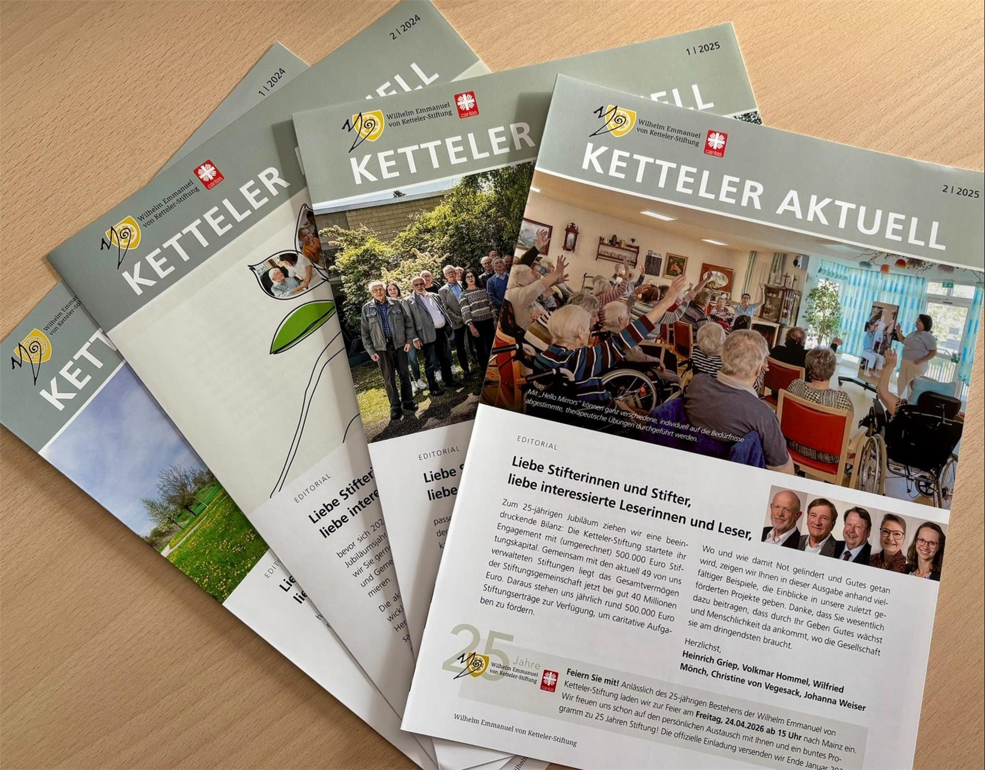 Die letzten vier, verschiedenen Ausgaben des Newsletters Ketteler Aktuell liegen aufgefächert übereinander.