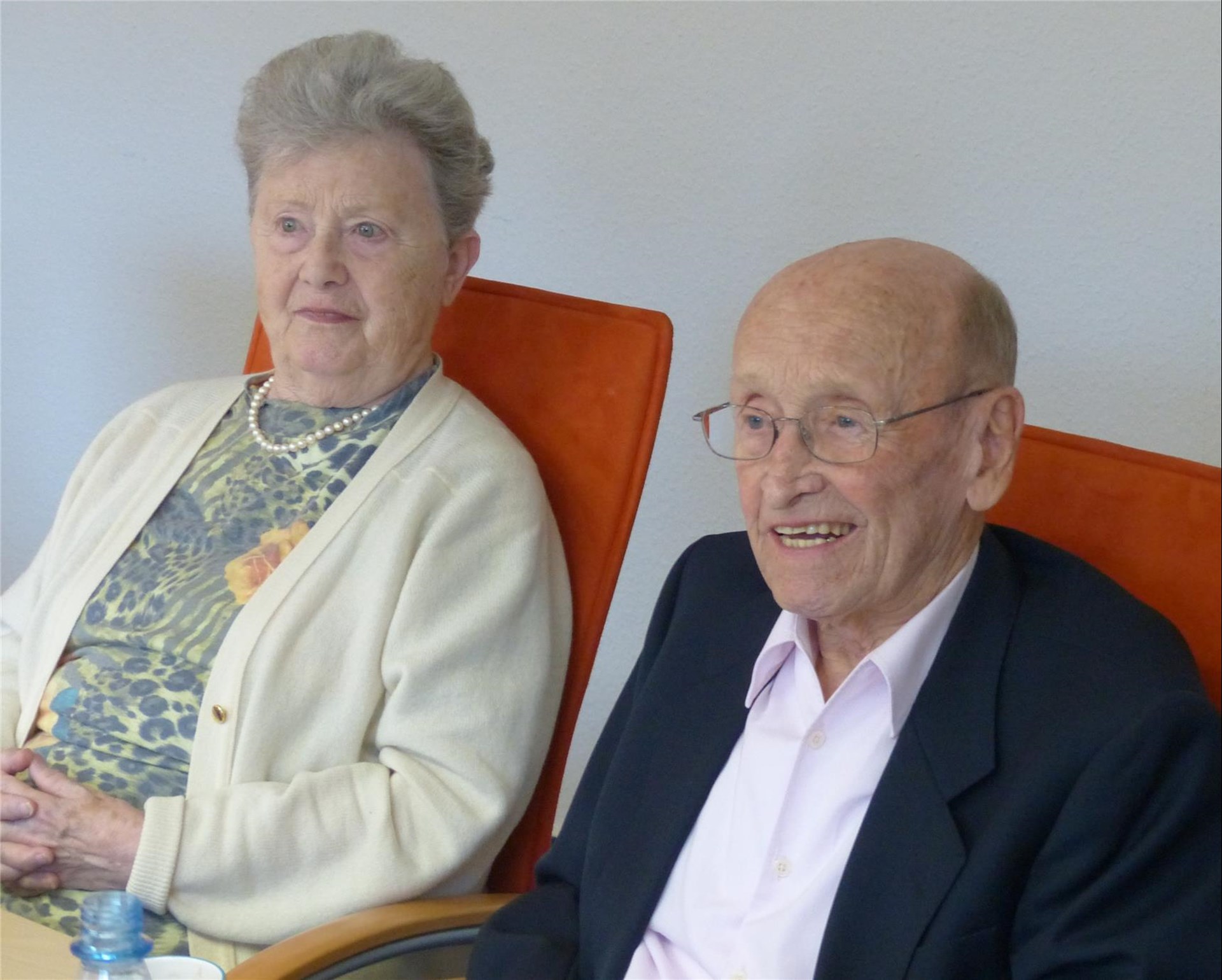 Das Stifterehepaar Heinz und Gisela Schaefer sitzt auf orangenen Stühlen