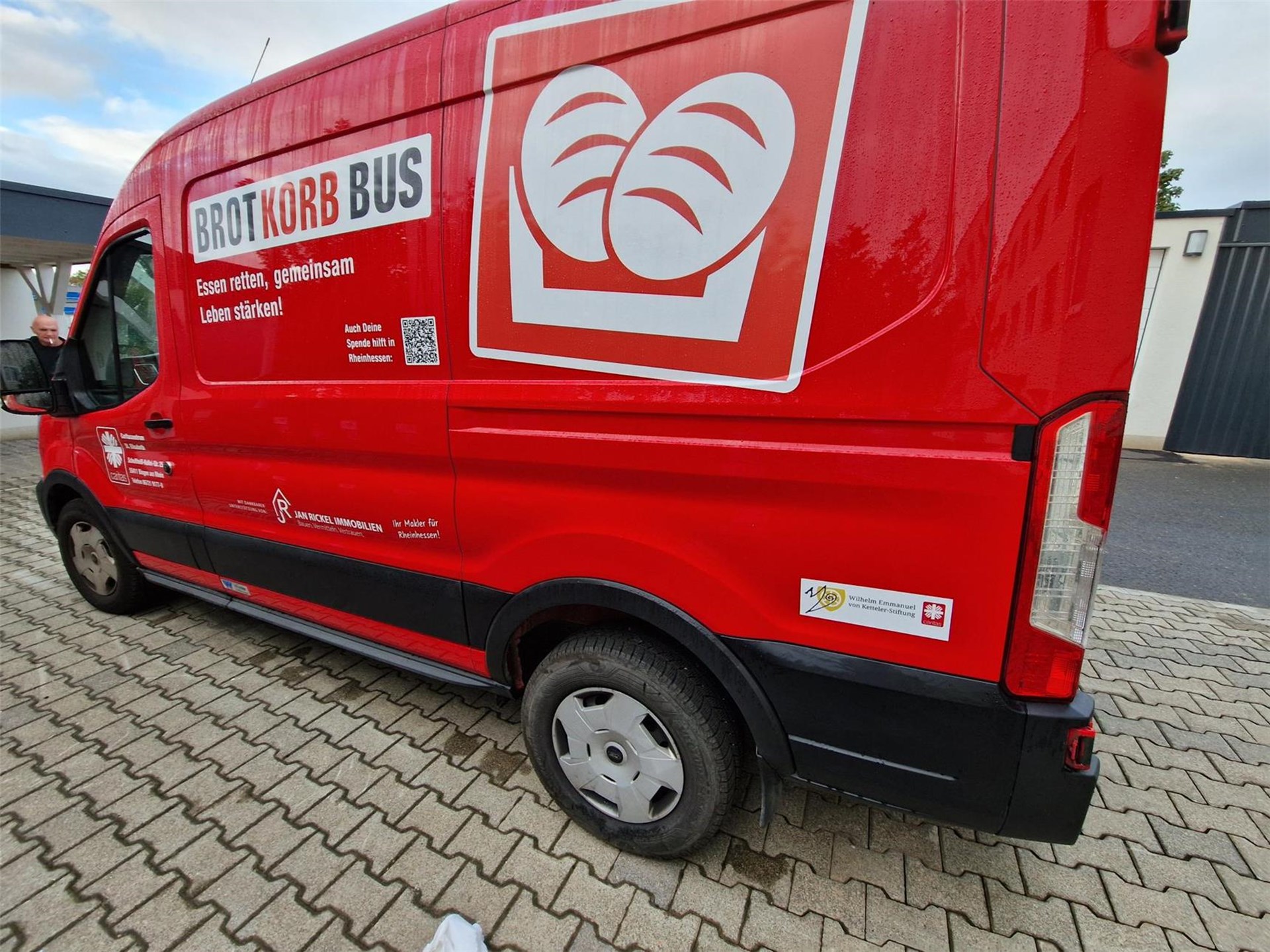 Das Foto zeigt einen roten Fort Transit-Transporter, der als Kühlfahrzeug für den Brotkorb Bingen der Caritas im Einsatz ist.